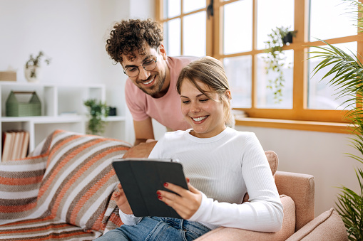 Young couple using digital tablet at home