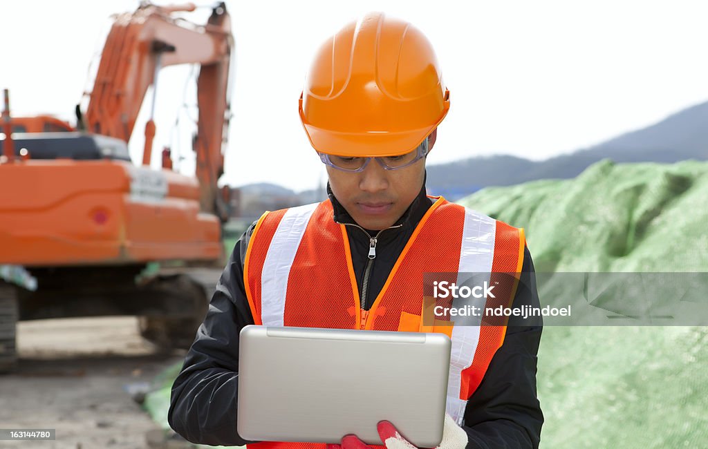 Construção de Estrada trabalhador usando computador portátil - Foto de stock de Escavadora Mecânica royalty-free