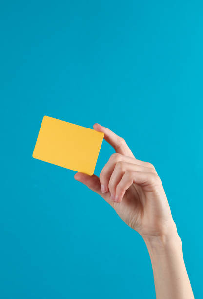 istock Woman's hand holds a golden empty bank card on a blue background 1631481521