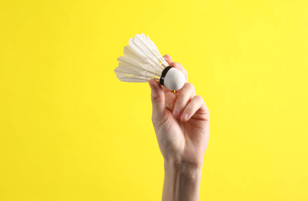 istock Hand holds shuttlecock on yellow background 1631482645