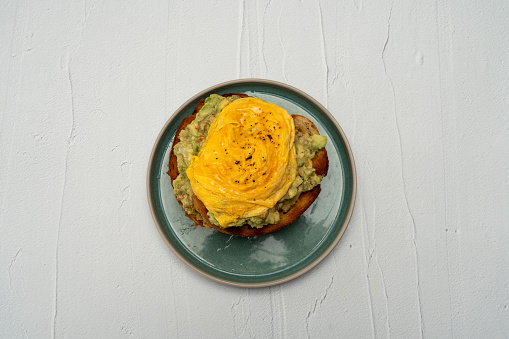 healthy breakfast with scrambled eggs guacamole on a toast