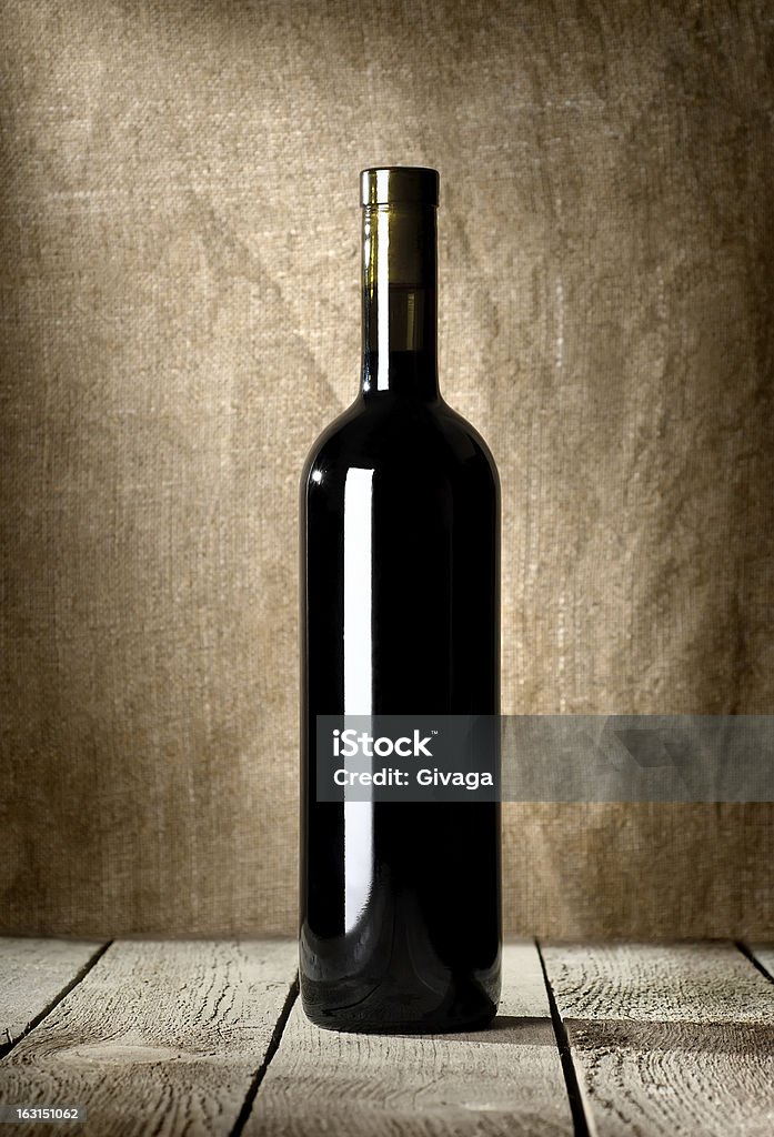 Black bottle of red wine Black bottle of wine on the background of the canvas Alcohol - Drink Stock Photo