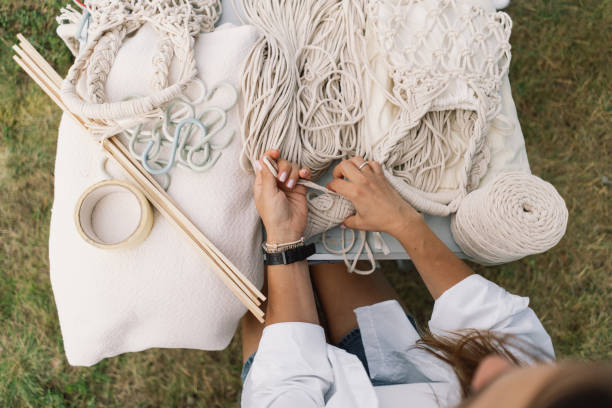 istock Woman knits bag using macrame technique outdoors near tents 1631511409
