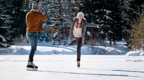 istock Man photographing woman on snow 1631512063