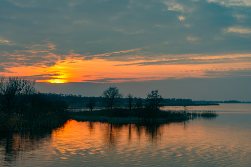 Sunset over the Weerribben-Wieden nature reserve in Overijssel, The Netherlands during a cold winter evening.