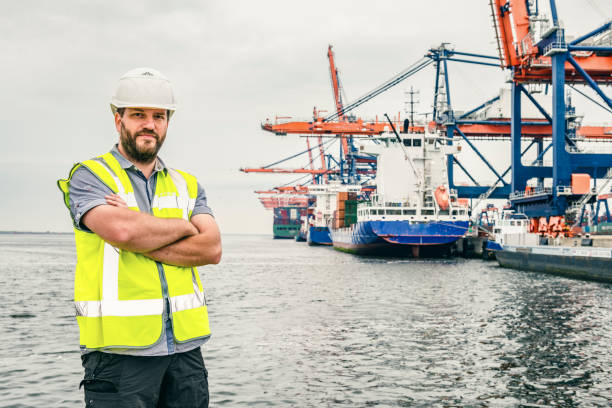 istock Dockworker with tablet computer in front of a container terminal with ships in port 1631520174
