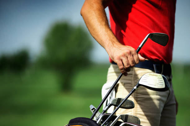Young man taking choosing a club at a golf course driving range.