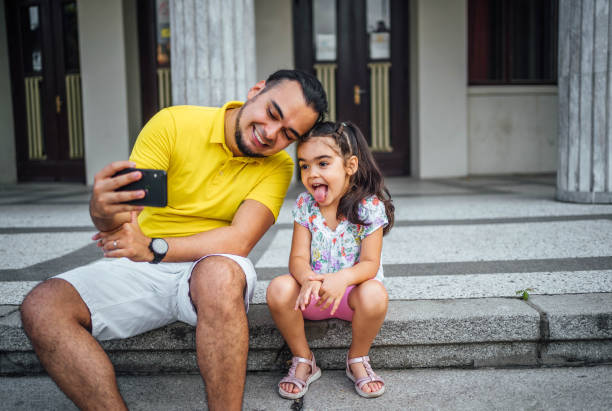 istock Father and daughter taking selfies 1631524139