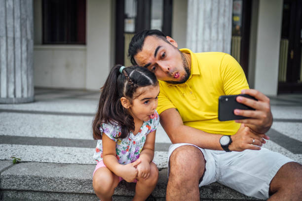 istock Father and daughter taking selfies 1631525043