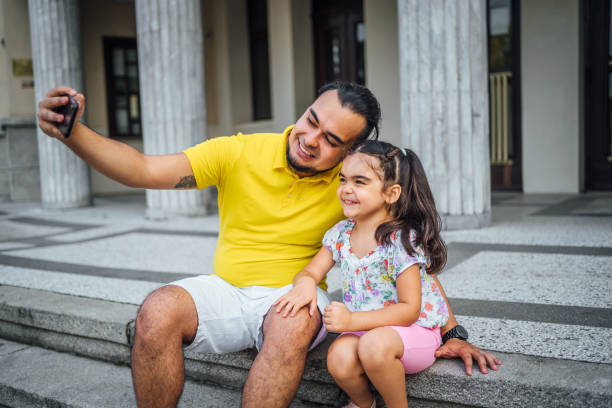 istock Father and daughter taking selfies 1631527487