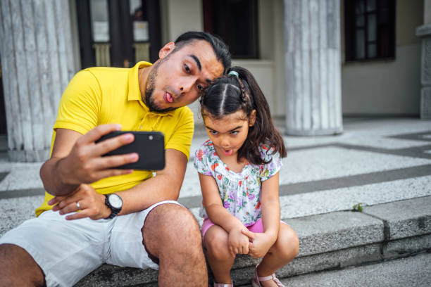 istock Father and daughter taking selfies 1631528048