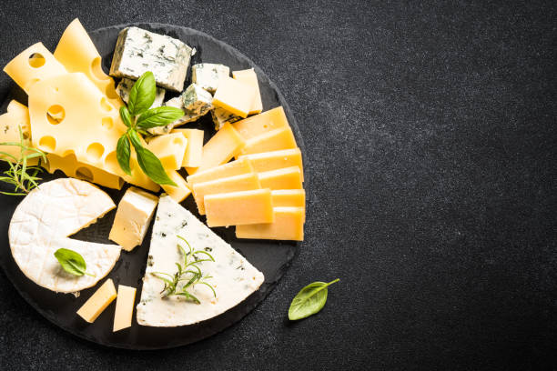 istock Cheese platter with craft cheese assortment at black background. 1631528613