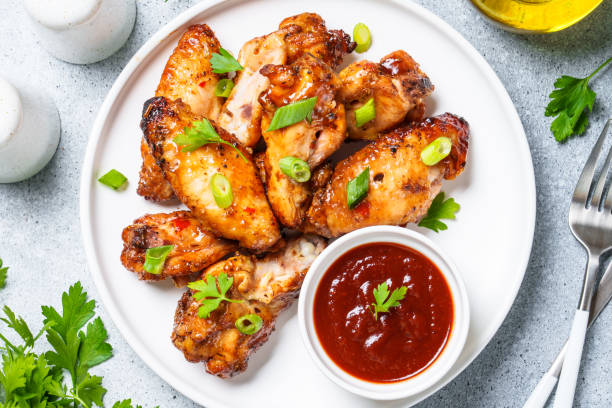 Chicken wings in bbq sauce at white table.