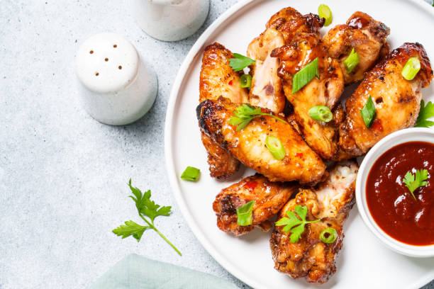 istock Chicken wings in bbq sauce at white table. 1631555343