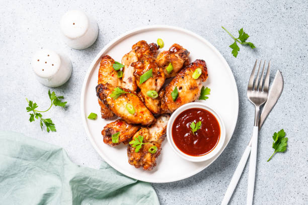 istock Chicken wings in bbq sauce at white table. 1631555345