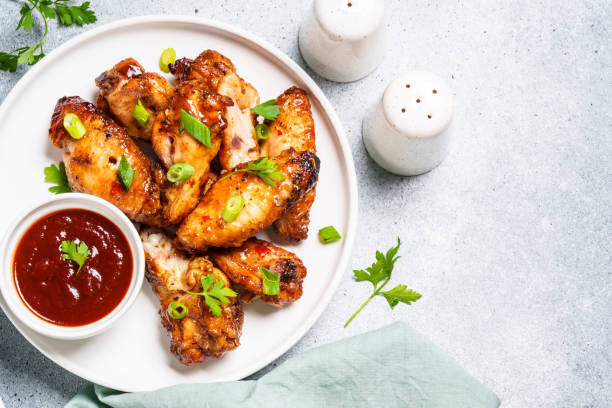 istock Chicken wings in bbq sauce at white table. 1631555351