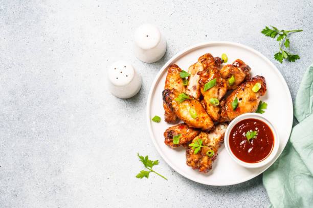 istock Chicken wings in bbq sauce at white table. 1631555384