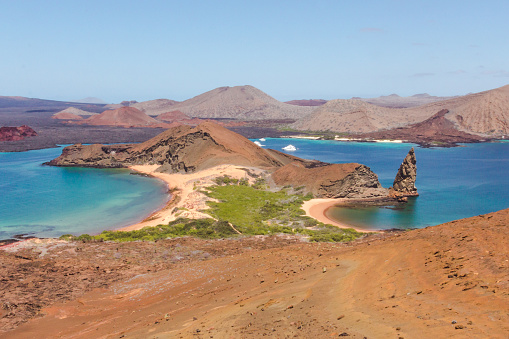 Landmark of volcanic landscape of San Bartolomé Island in the Galápagos Islands, Ecuador, during a sunny day. Crystal waters and peacefull bays with isolated landscapes are common in this archipelago.