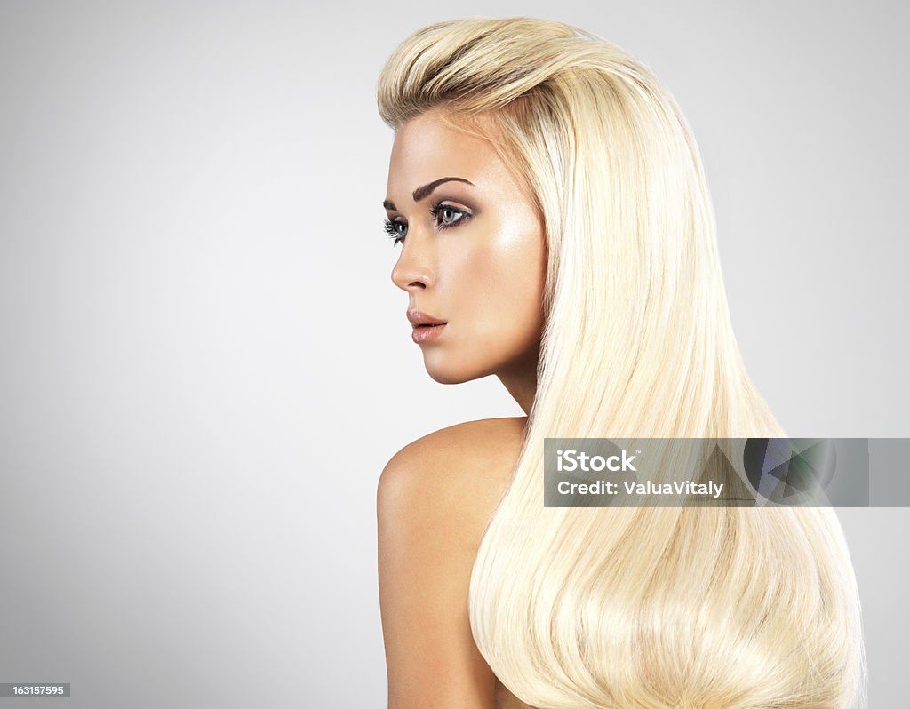 Blond woman with long straight hairs Beautiful woman with long straight blond hairs. Fashion model posing at studio. Profile View Stock Photo