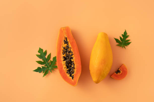 istock Cut Papaya over orange table background for tropical fruit design concept. 1631584162