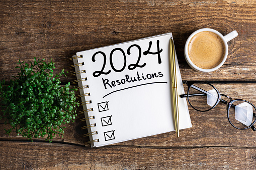 Resoluciones de año nuevo 2024 en escritorio. Lista de resoluciones 2024 con cuaderno, taza de café en la mesa. Metas, resoluciones, plan, acción, concepto de lista de verificación. Plantilla de Año Nuevo 2024 photo
