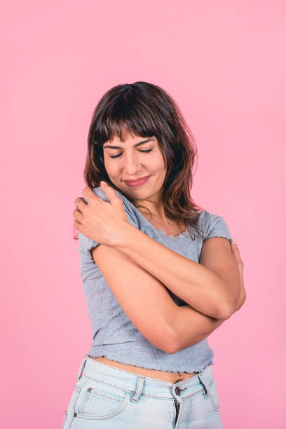 istock a woman with her eyes closed is hugging herself 1631595124