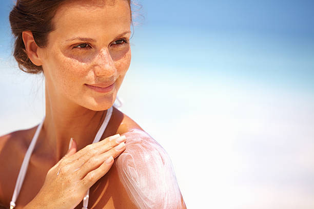 Lovely woman applying lotion Closeup of lovely young woman applying sunscreen lotion on body uv protection photos stock pictures, royalty-free photos & images