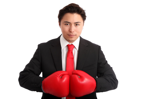 Young man in boxing gloves against white background.