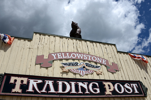 Cooke City, MT, 07-12-2013
wooden commercial sign of Yellowstone Trading Post in Cooke City with black bear figurine on top of facade