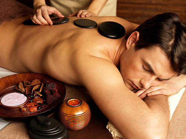 uomo con massaggio di pietra nel salone spa - spa treatment health spa wellbeing lastone therapy foto e immagini stock