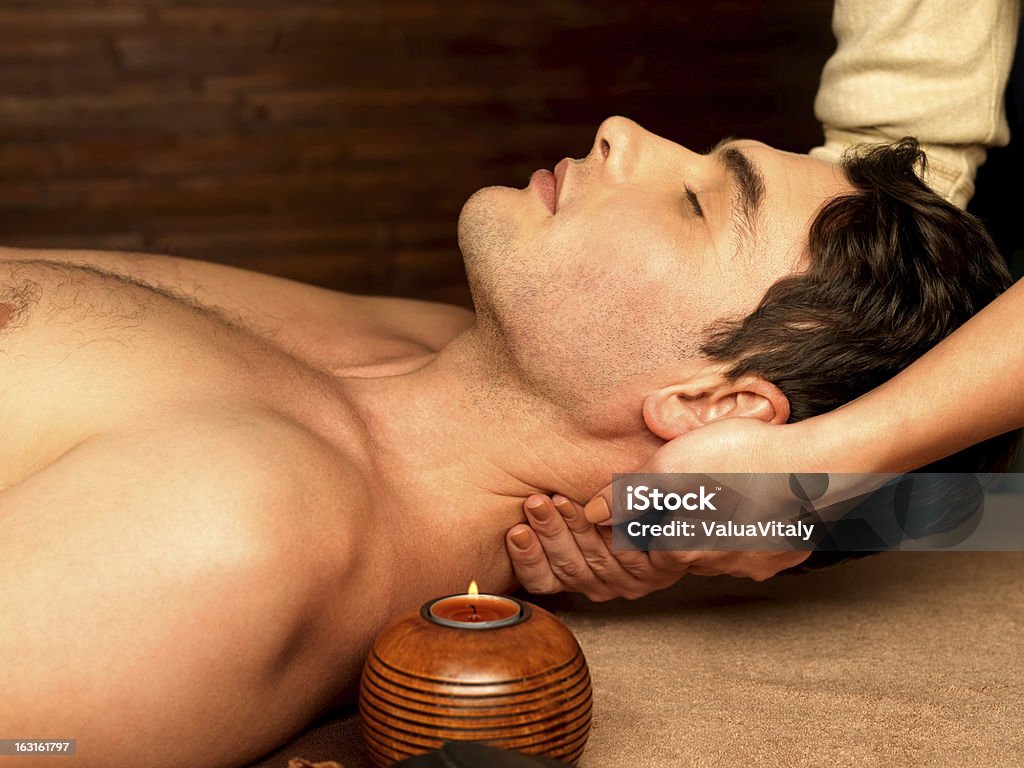 Man having neck massage in the spa salon Masseur doing neck massage on man in the spa salon. Men Stock Photo