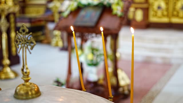 burning candles in the church on the altar.