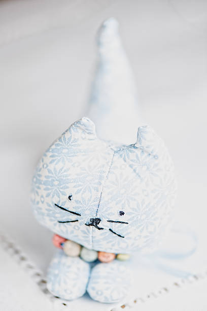 istock Homemade toy cat on white cloth 163162459
