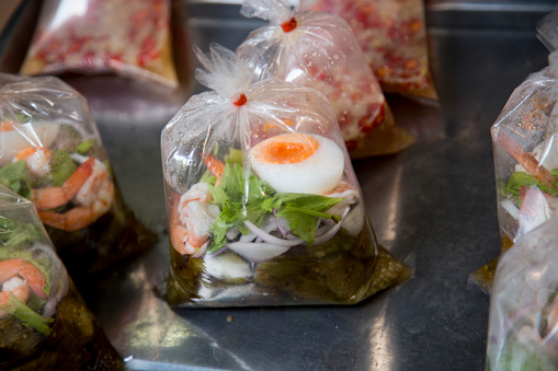 Food in plastic bags in a street food stall in Bangkok, Thailand..