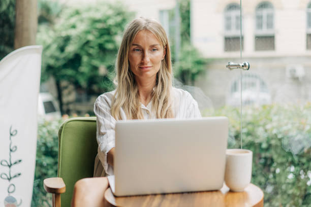 istock Remote working woman typing on a laptop while sitting in a coffee shop. 1631627266