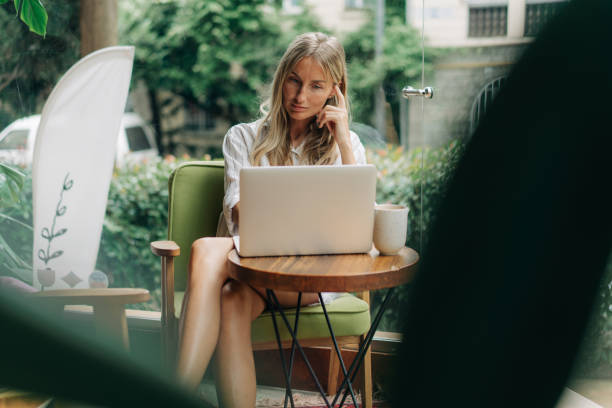 istock Remote working woman typing on a laptop while sitting in a coffee shop. 1631627271