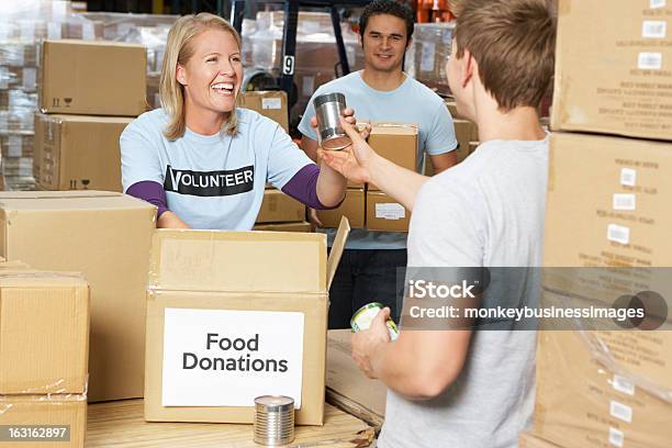 Volunteers Collecting Food Donations In Warehouse Stock Photo - Download Image Now - Volunteer, Food Bank, Coworker