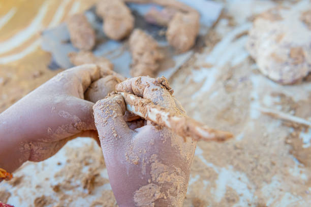 Boy making drawing on a piece of clay made from natural clay rocks
