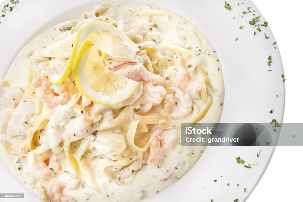 Seafood Fettuccine Alfredo Seafood Fettuccine Alfredo isolated on white with shrimp, crab and other seafood Bechamel Sauce Stock Photo