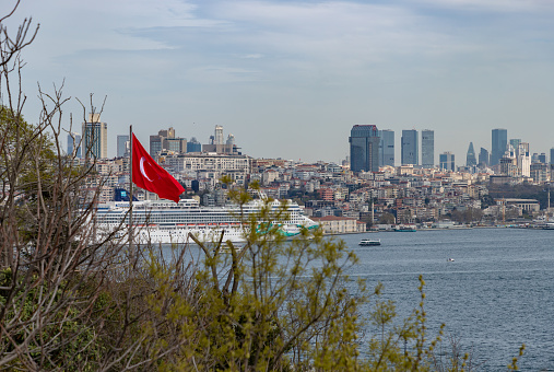 Istanbul, Turkey - April 15, 2023: A picture of a Cruise Ship docked on the Galataport, part of the Beyoglu district, with high rises on the right side.