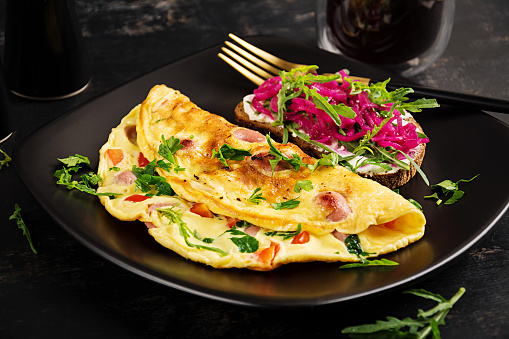 Breakfast. Omelette with sausage, sweet peppers and sandwich with marinated red onions. Frittata - italian omelet.