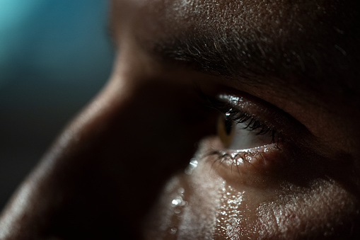 Sad man crying in living room late at night. Depression concept.