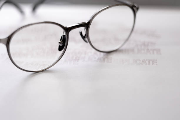 istock Spectacles placed on top a piece of paper with the word duplicate. 1631662955