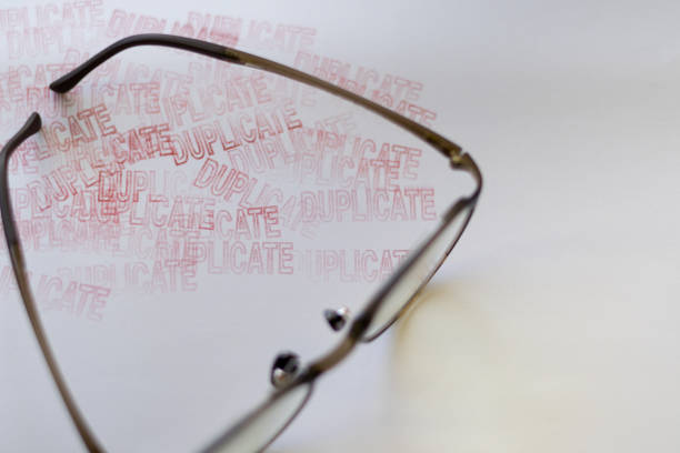 Glasses beside keyboard computer on wooden table