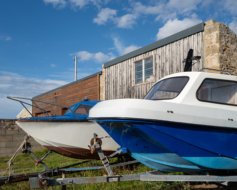 20 August 2023. Hopeman,Moray,Scotland. This is two small pleasure boats on trailers, dry docked at Hopeman Harbour.