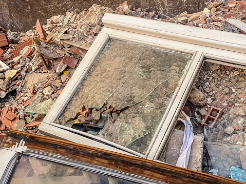 High angle view of window frame with broken glass inside garbage container in the street