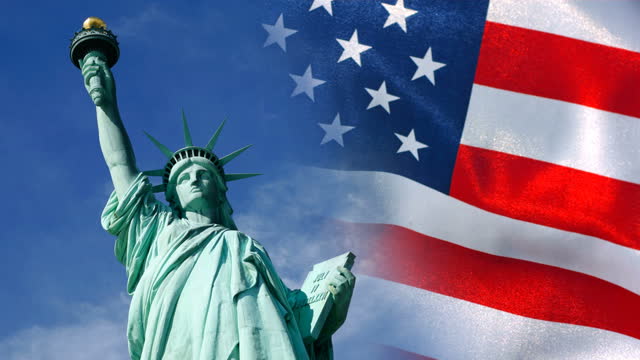 Statue of Liberty and United States flag waving in wind