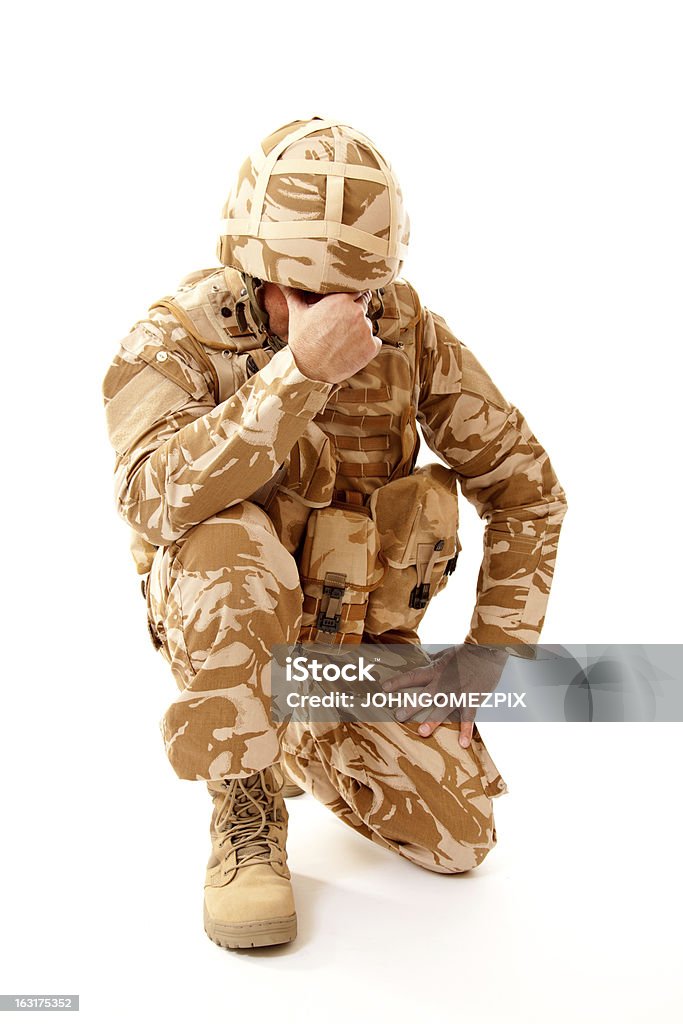 Shell Shocked Soldier A distraught soldier on one knee with one hand covering his face, possibly suffering from shell shock or Post Traumatic Stress Disorder Armed Forces Stock Photo