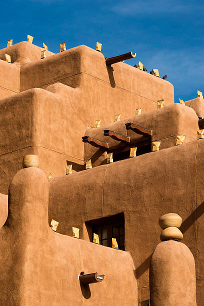 Tall adobe structure Tall adobe building with luminaria for the holidays in Santa Fe, New Mexico santa fe new mexico stock pictures, royalty-free photos & images
