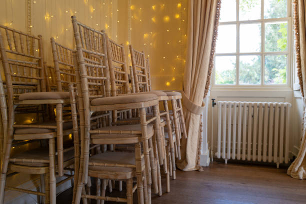 Stacked ornate chairs used in a wedding ceremony.